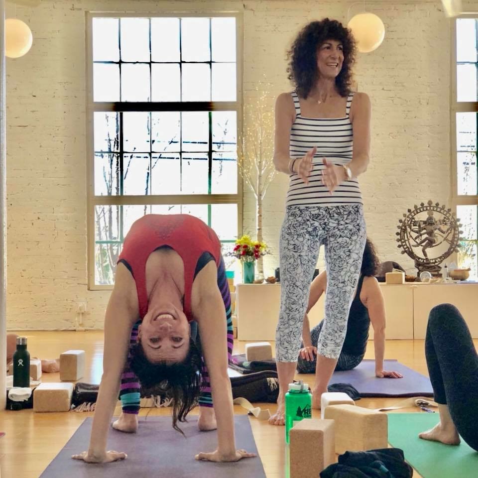 instructor assisting yoga student doing pose